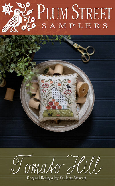 A white house with tomatoes at the front and tomato vines all around.