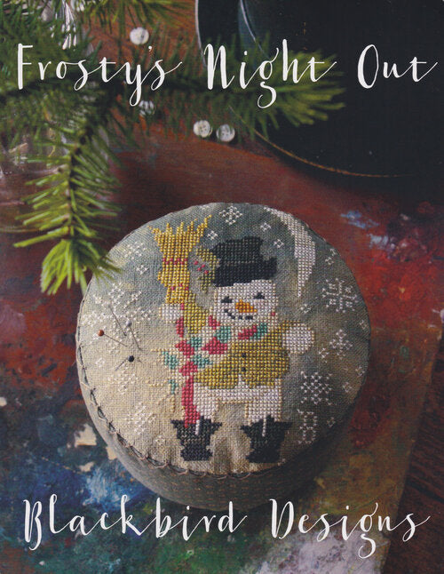 A snowman standing in the snow with a colourful scarf and a broom in his hand.